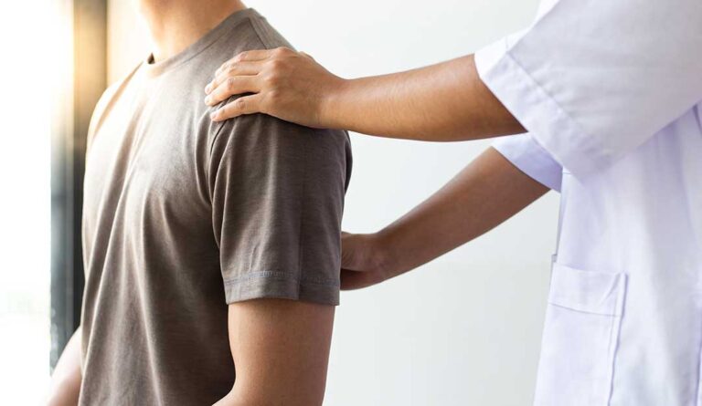 Adult receiving gentle spinal care while discussing neck tension with a practitioner in a quiet treatment room.