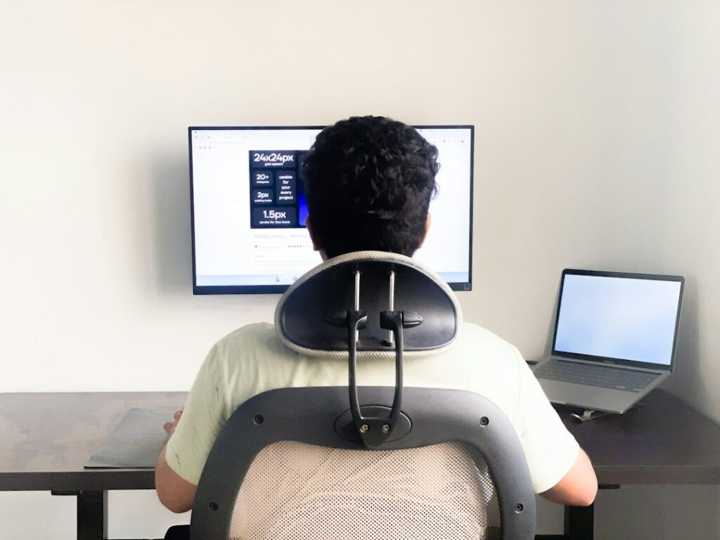 Child sits at a desk with a laptop, supported feet, relaxed shoulders, and an adjustable chair.