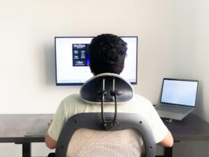 Child sits at a desk with a laptop, supported feet, relaxed shoulders, and an adjustable chair.
