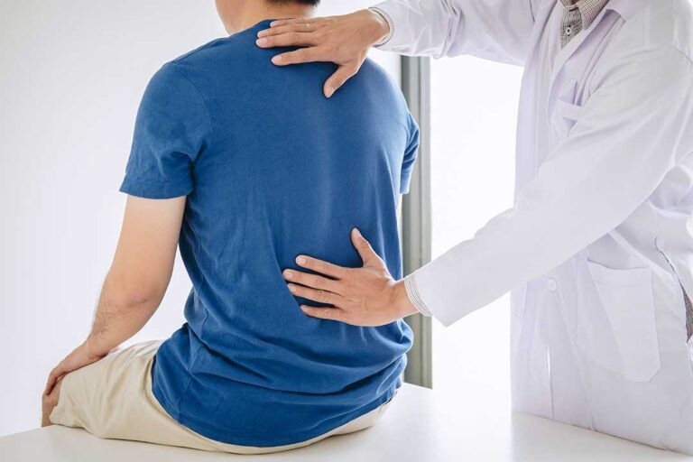 Adult doing gentle range-of-motion exercises beside a warm compress on a painful knee.